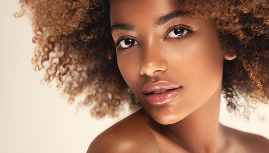 Expresión romántica y sonrisa ligera en la cara de la joven mujer de piel marrón. Belleza afro. photo