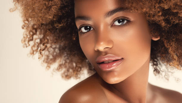 expresión romántica y sonrisa ligera en la cara de la joven mujer de piel marrón. belleza afro. - chicas hermosas fotografías e imágenes de stock
