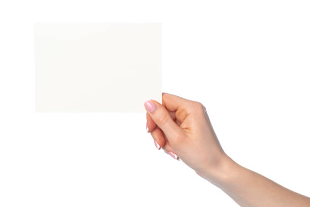 istock Woman's hand holding blank white sheet of paper isolated on white 1294560413