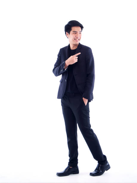 istock Handsome man in black suit pointing on white background 1294561594