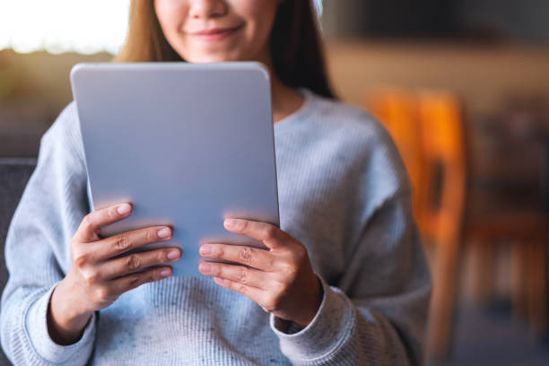 istock a beautiful young asian woman holding and using digital tablet 1294561670