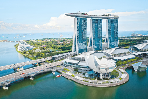 Singapore, June 14, 2019. Aerial view of the famous landmark, Marina Bay Sands in Singapore seen a sunny day. The hotel is shaped like a boat with a large infinity pool on the roof. The Art Science museum seen in the front and Flower Dome and Forest Cloud in the Gardens By The Bay seen at back.