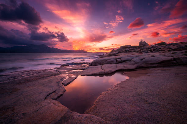 coucher du soleil au-dessus de la tour et du littoral rocheux de la corse - balagne photos et images de collection