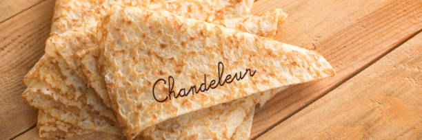 Close up on a stack of folded crepes (french pancakes) on panoramic wooden background, word Chandeleur Close up on a stack of folded crepes (french pancakes) on panoramic wooden background, word Chandeleur candlemas stock pictures, royalty-free photos & images