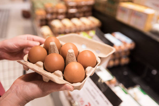 Woman buys eggs in the supermarket stock photo