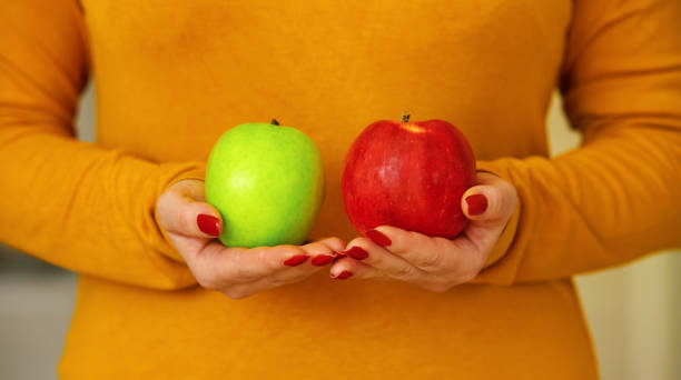 istock Woman holding two apples 1294571765
