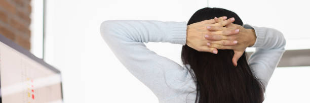 istock Woman putting her hands behind head at table in office 1294571802