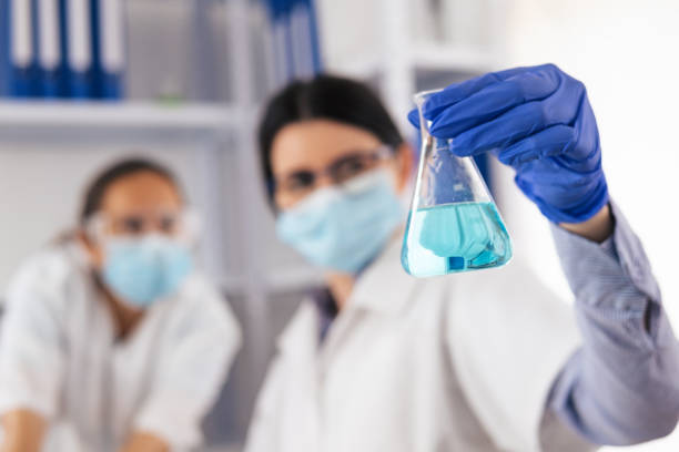 istock Coronavirus protection. Scientific researches in microbiological laboratory on COVID-19 vaccine elaboration in medical clinic. Female doctors wearing protective face masks looking at microbiology samples through a medical microscope and discussing. 1294572072