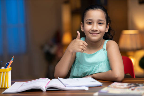 自宅で子供の女の子の勉強 - ストック写真 - thumbs up book smiling student ストックフォトと画像