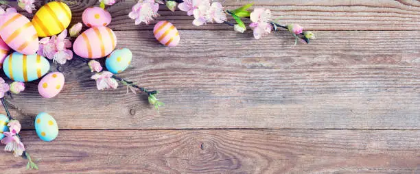 Photo of Gift card with colorful easter eggs on old wooden table.