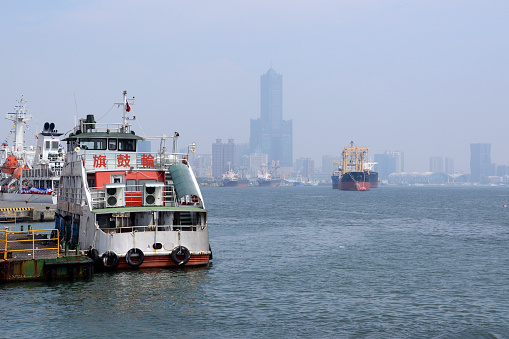 Ferry moored on Kaohsiung harbor with the 85 sky tower in the distance. Taiwan