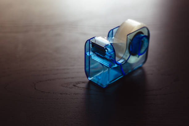 Blue tape dispenser with translucent tape on black office table