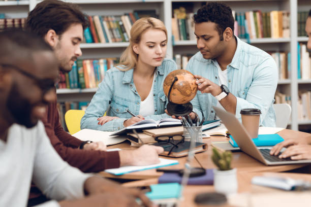 istock Group of ethnic multicultural students in library. Students are studying. 1294582712