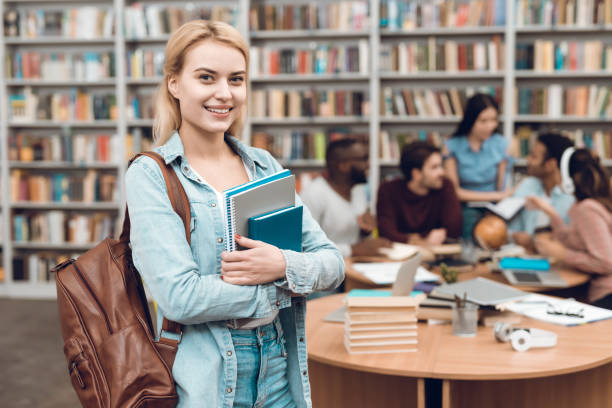 istock Group of ethnic multicultural students in library. White girl with notebooks. 1294582832