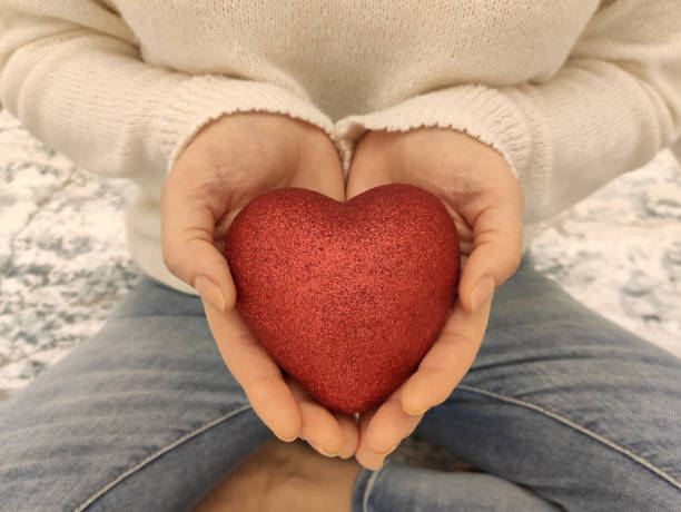istock Woman hand holding a red heart 1294583666