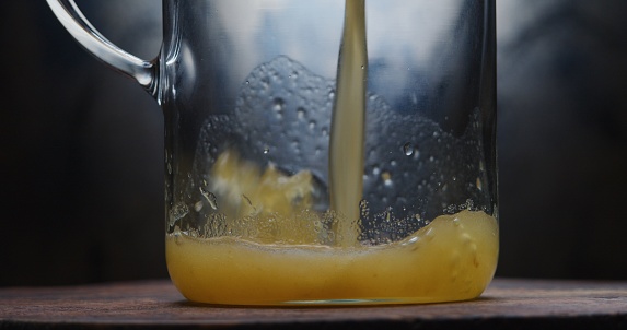 Pouring yellow smoothie into the jug