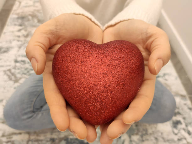 istock Woman hand holding a red heart 1294583742