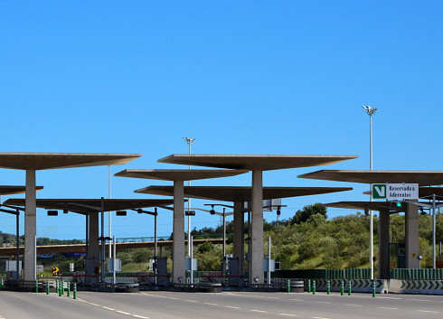 Paderne / Albufeira, Algarve / Faro district, Portugal: modern concrete structure of the Paderne toll-plaza on the A2 motorway, gate to the Algarve - the right lane is for Via Verde, the Portuguese contactless electronic toll collection system - Portagem de Paderne, Autoestrada do Sul A2.