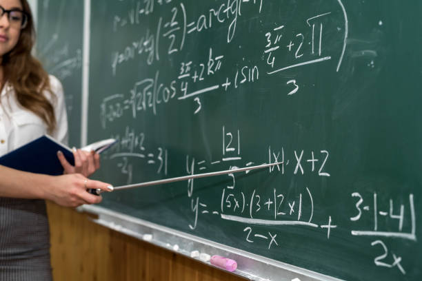 istock Woman teacher writed mathematical formulas on the blackboard and explain a lesson. 1294584545
