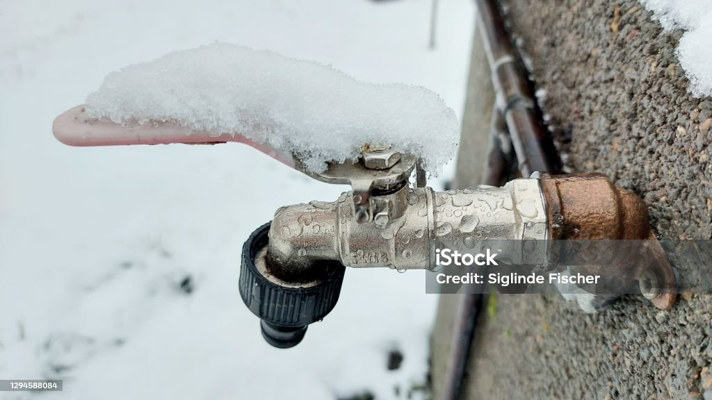 Faucet covered by snow In the garden, 1st snow 2021 Faucet Stock Photo