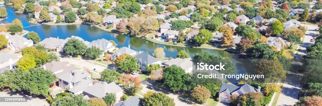 Panoramic top view upscale lakeside neighborhood with colorful autumn leaves in Coppell, Texas, USA Panorama aerial view upscale lakeside neighborhood in Coppell, Texas, America. Top view residential houses surrounded by colorful fall foliage in sunny autumn day Texas Stock Photo
