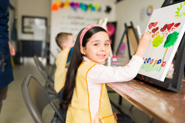 istock Beautiful latin kid is smiling during her painting class 1294592898