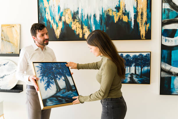 istock Painter holding his painting to show it to a customer 1294596602