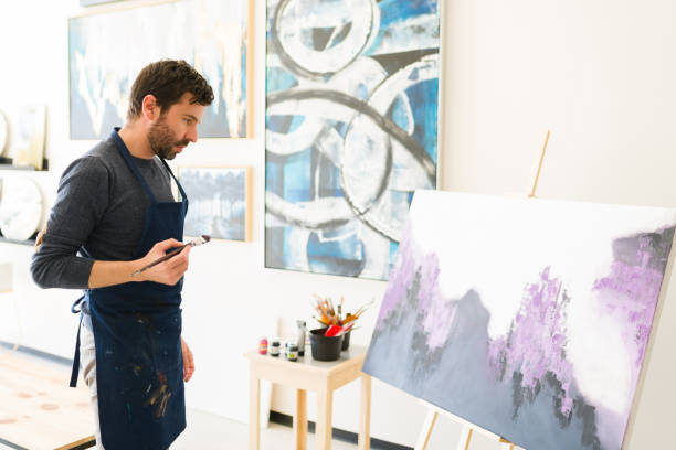 istock Male painter admiring and studying his new painting 1294596658