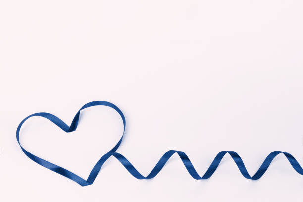 istock Heart shape made of classic blue ribbon on a white background 1294597237