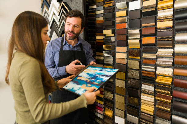 istock Attractive client and handsome salesman at the frame store 1294597922