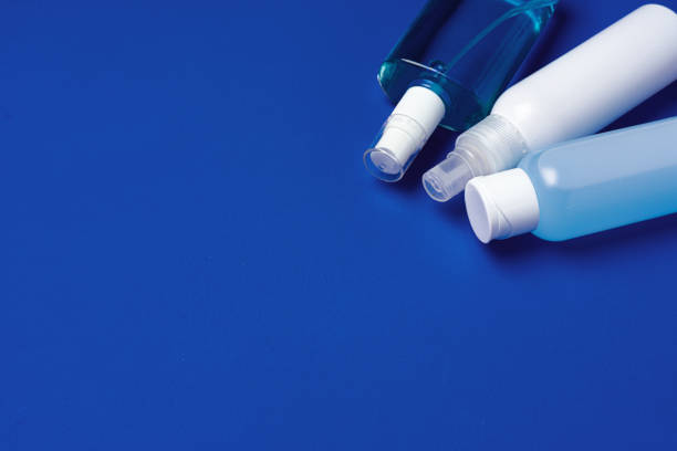 istock Bottles with antibacterial hand sanitizer on blue background with copy space 1294601481