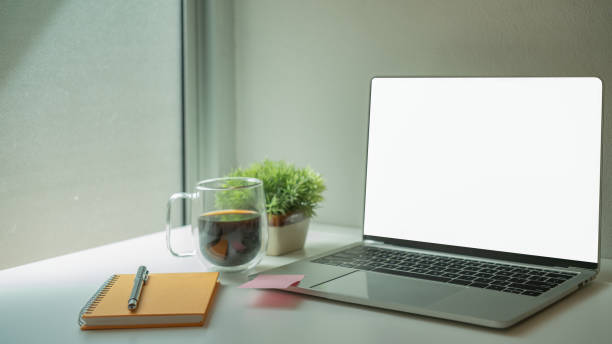 istock Laptop with white blank screen putting on a modern white table. 1294602547