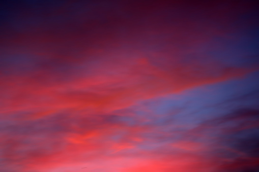 Pink sunset sky background. Picturesque colorful red clouds in the sky. Blue sky background.