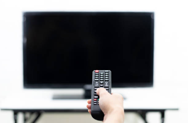 istock Hand holding the remote to turn on the TV 1294602935
