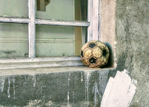 pallone da calcio still life - broken window concrete wall foto e immagini stock