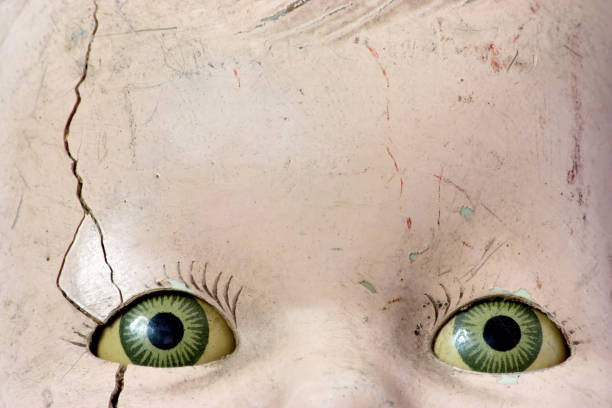 Creepy doll head with spooky green eyes.