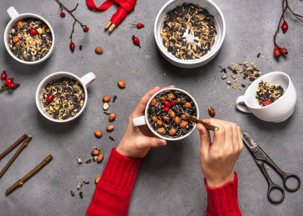 istock Step 5. Child inserting a branch into the cup with birdseeds and coconut. 1294608880