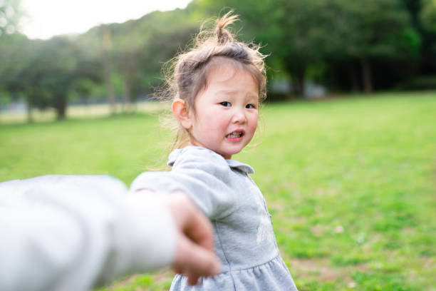 istock Toddler girl pulling parents' hands 1294609865
