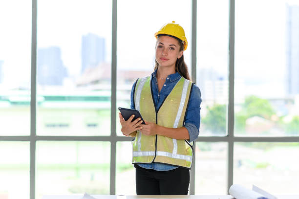 istock Portrait of female construction engineer workers in yellow hardhat with a tablet computer in construction site 1294611605