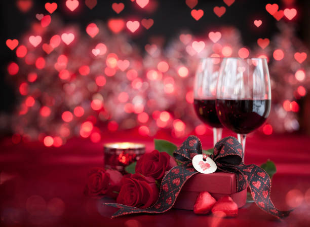 istock Valentine's Day Red Roses and Red Wine with a Gift on a Defocused Lights Background 1294611896