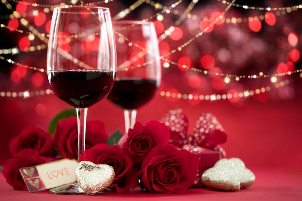istock Valentine's Day Red Roses and Red Wine with a Gift on a Defocused Lights Background 1294611928
