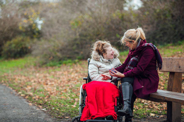 Mother and Daughter Using Smart Phone in Public Park