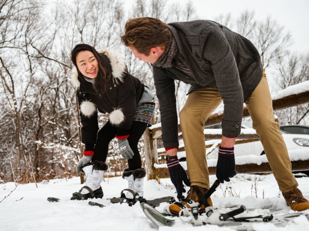 Mixed race couple snowshoeing in winter