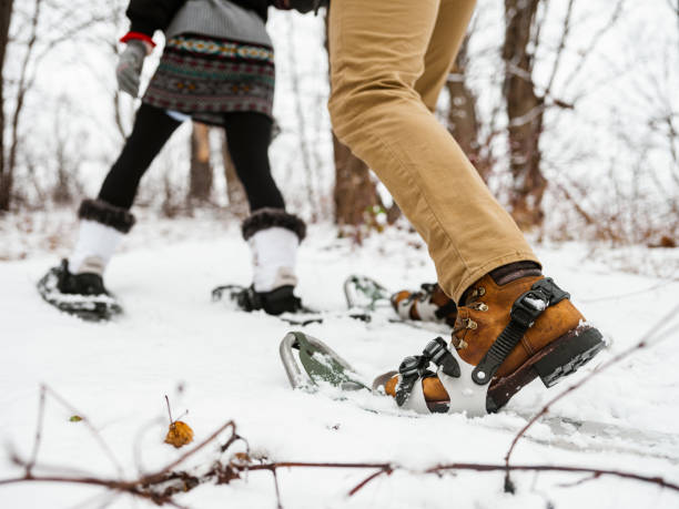 gemischtes rennpaar schneeschuhwandern im winter - snowshoeing snowshoe women shoe stock-fotos und bilder