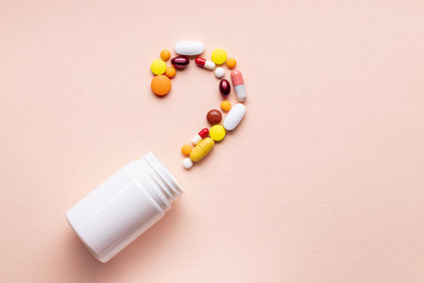 istock assorted pills and capsules near blank bottle isolated pink background. above view. pharmacy concept 1294622701