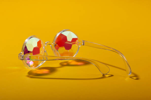 Kaleidoscope glasses on yellow background. Copy space. Summer concept. Close up.