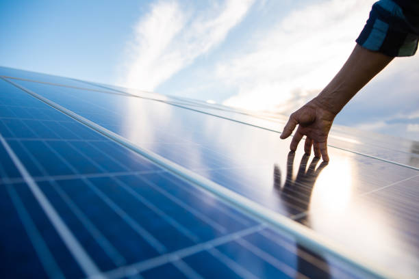 manos en panel solar que genera energía - energía sostenible fotos fotografías e imágenes de stock