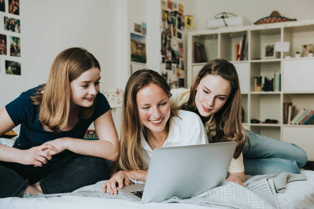istock three young woman looking together at laptop on bed 1294630363