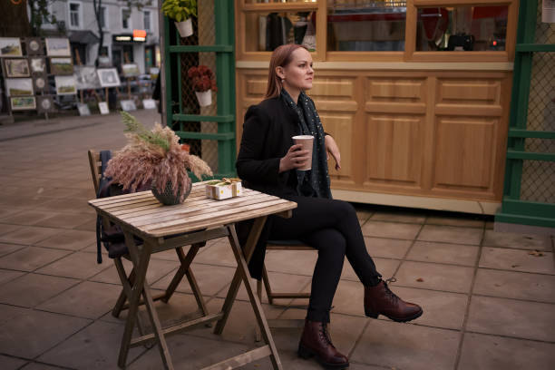 istock Woman drinking coffee at a street cafe table 1294632342