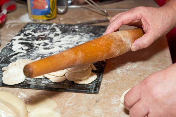 istock A hand holds a wooden rolling pin soiled in flour. Rolling out dough for making dumplings 1294634570